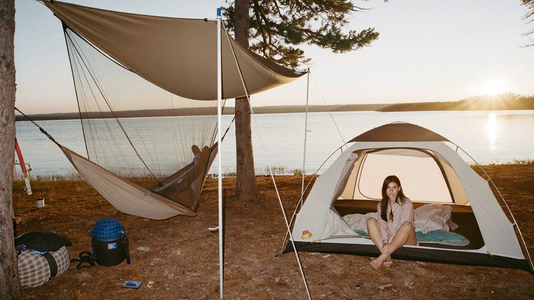 Hammock camping vs tent comparison at one lakeside campsite, with a hammock hung between pines beside a pitched dome tent at golden hour