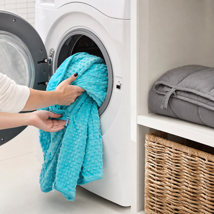 Placing the turquoise minky blanket cover into a front-loading washing machine